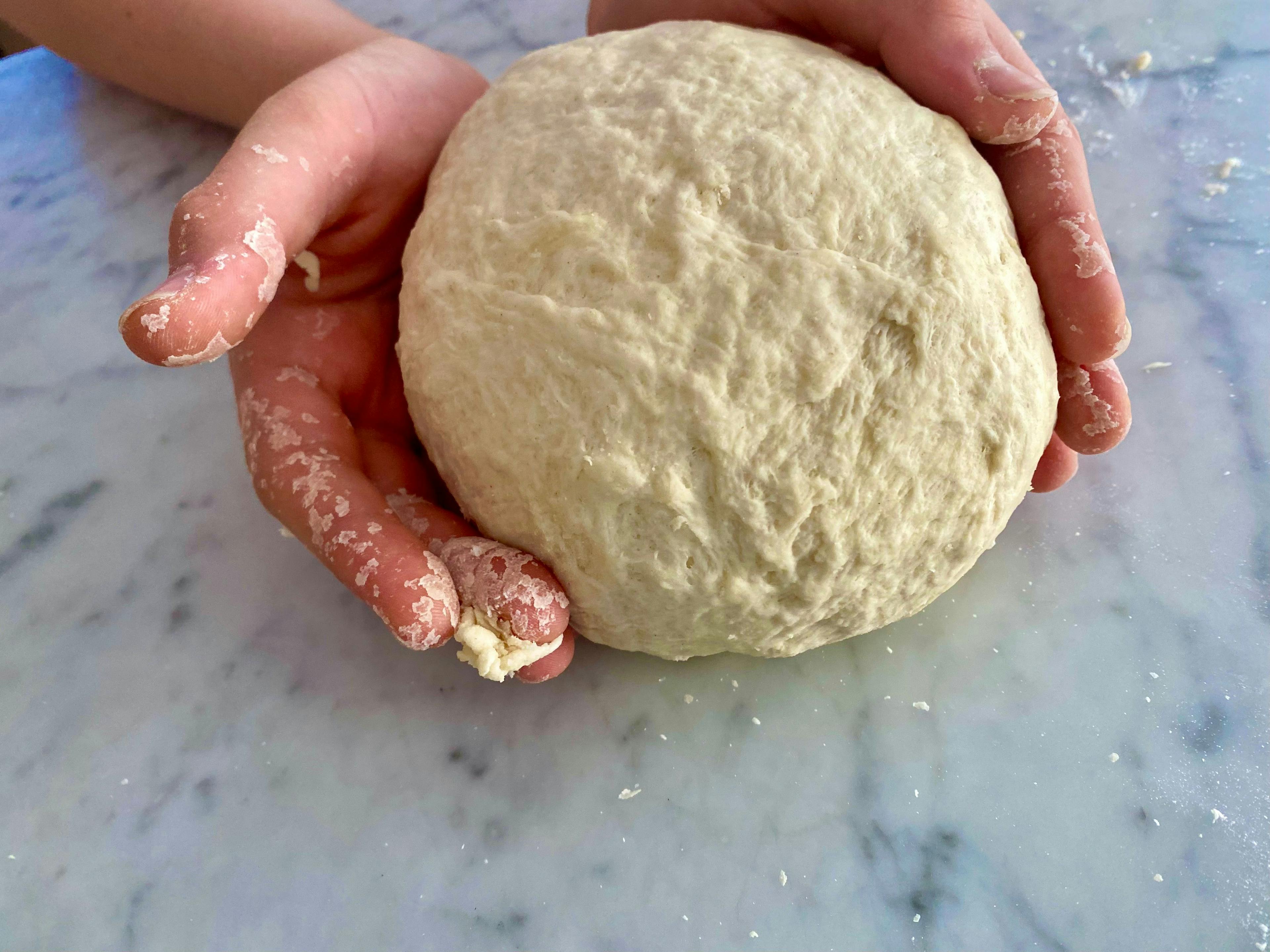 hands holding dough ball