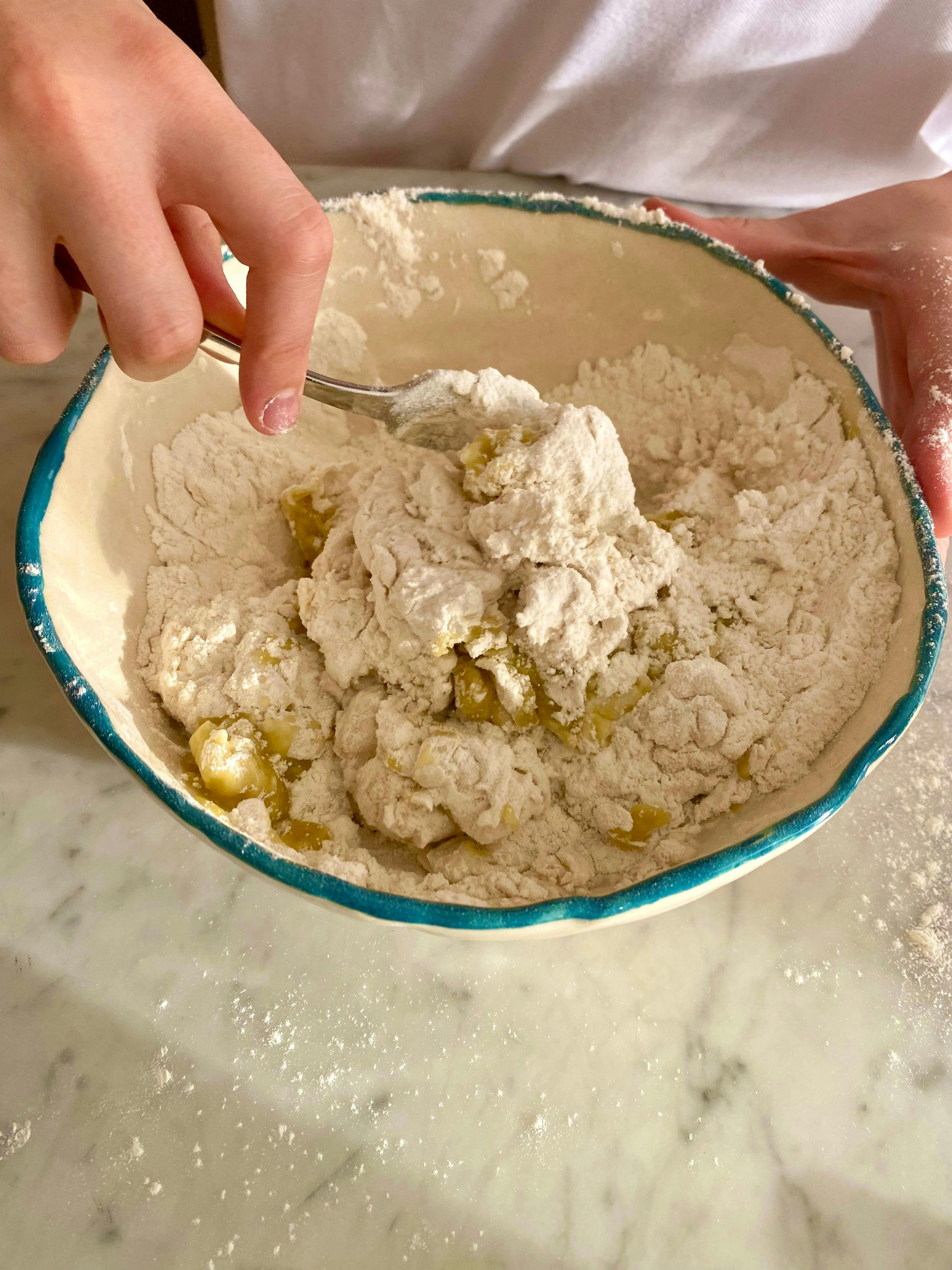 mixing bowl with flour, water oil and salt being mixed together