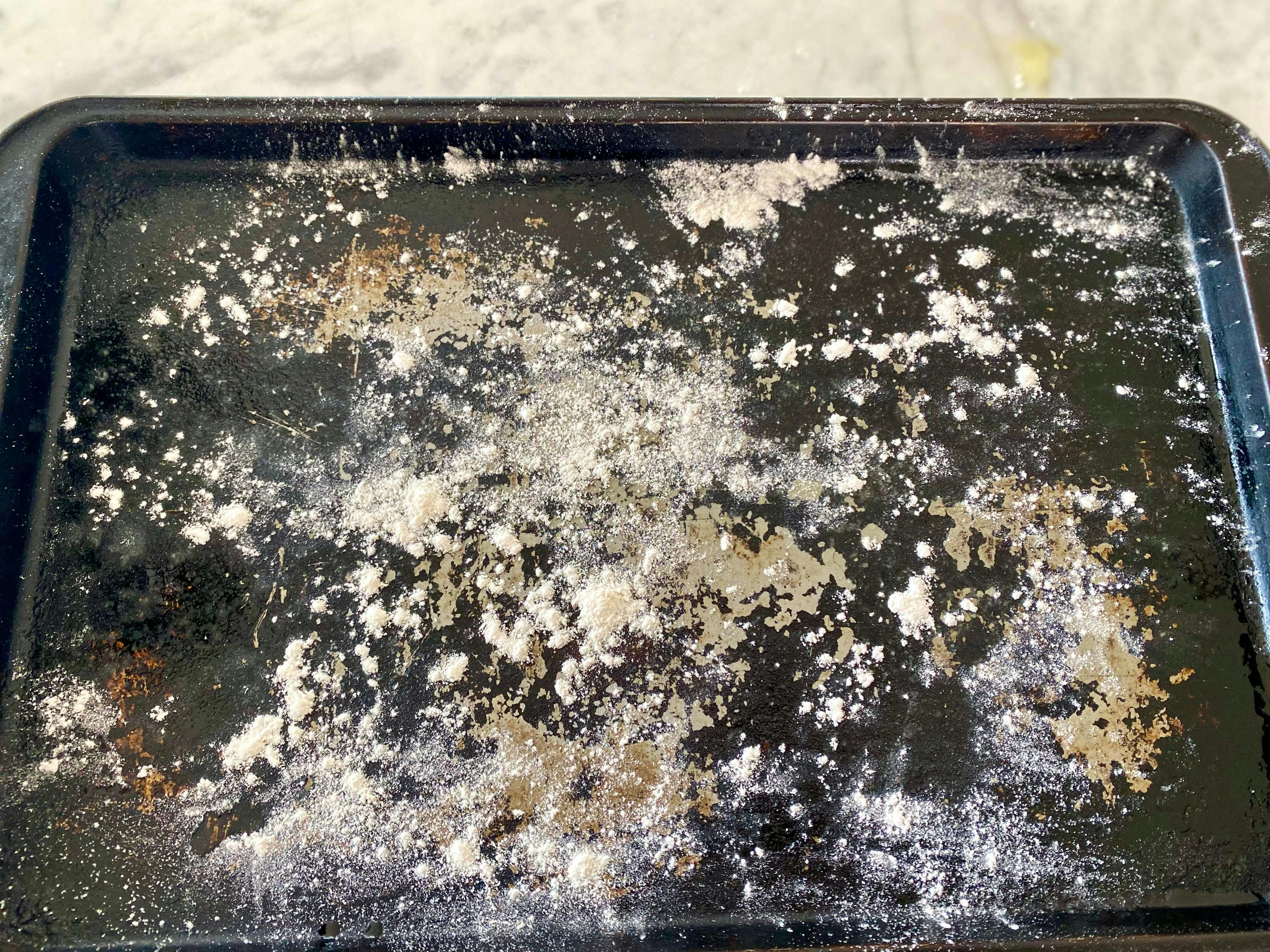 an oven tray with oil and a little flour sprinkled on