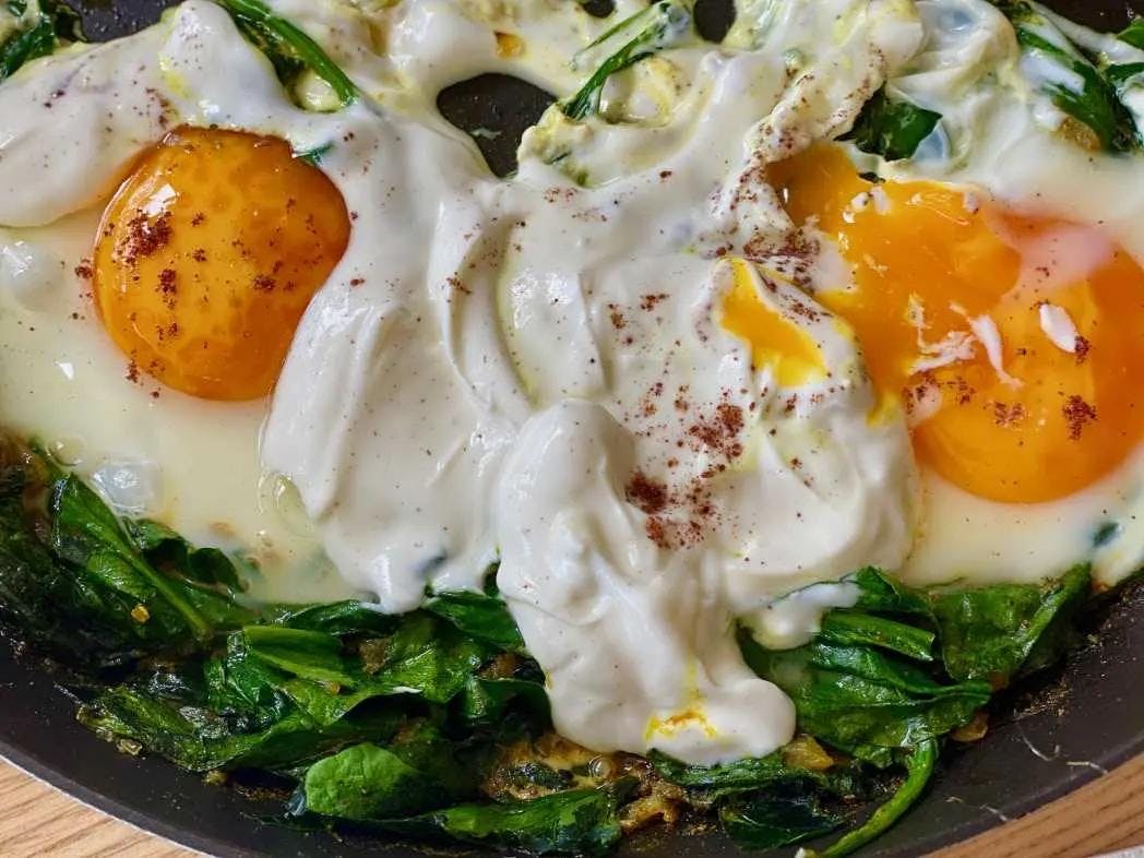 fried eggs on a bed of spinach