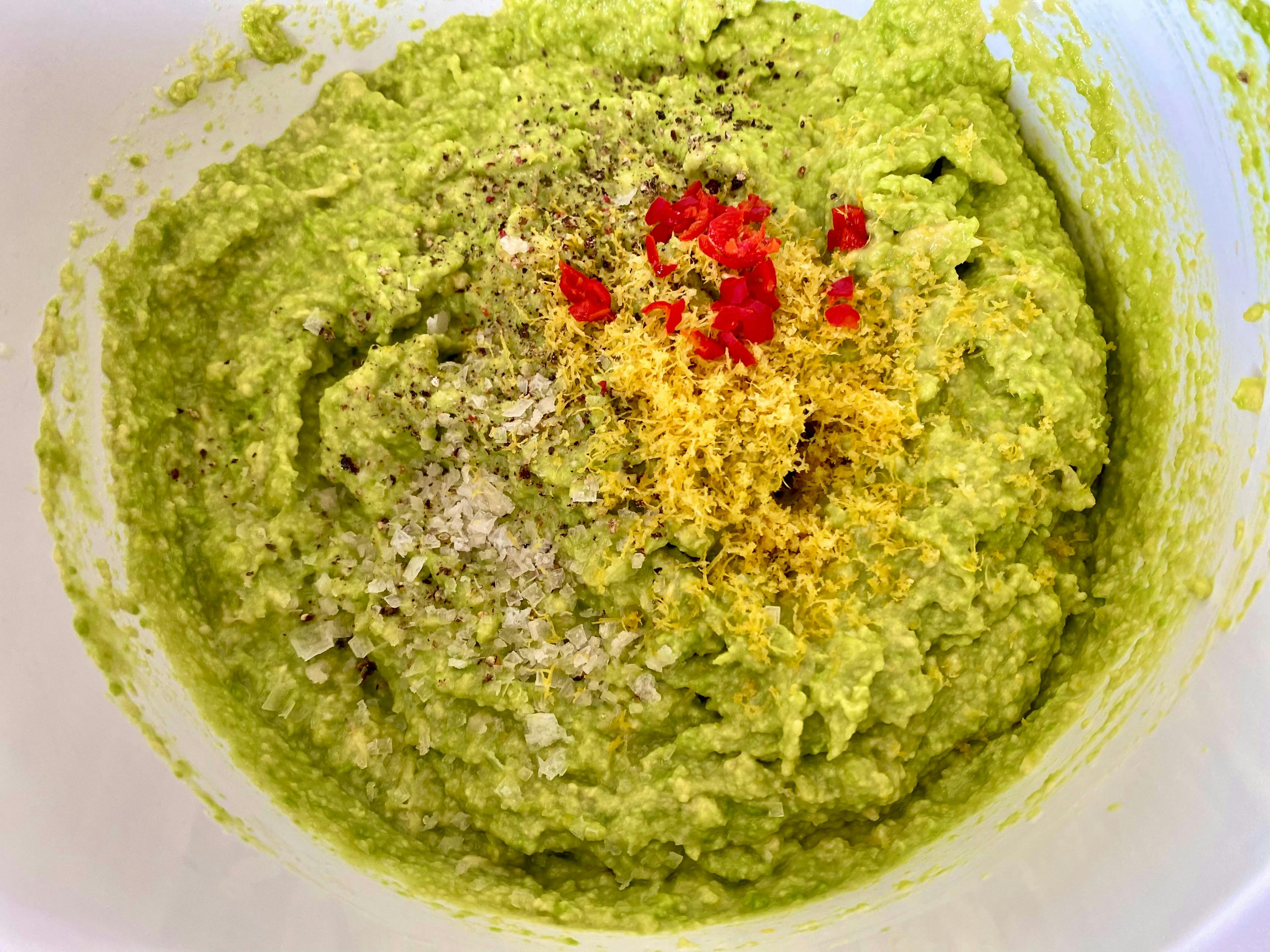 a bowl with mashed avocado, lemon pith, chilli and salt and pepper