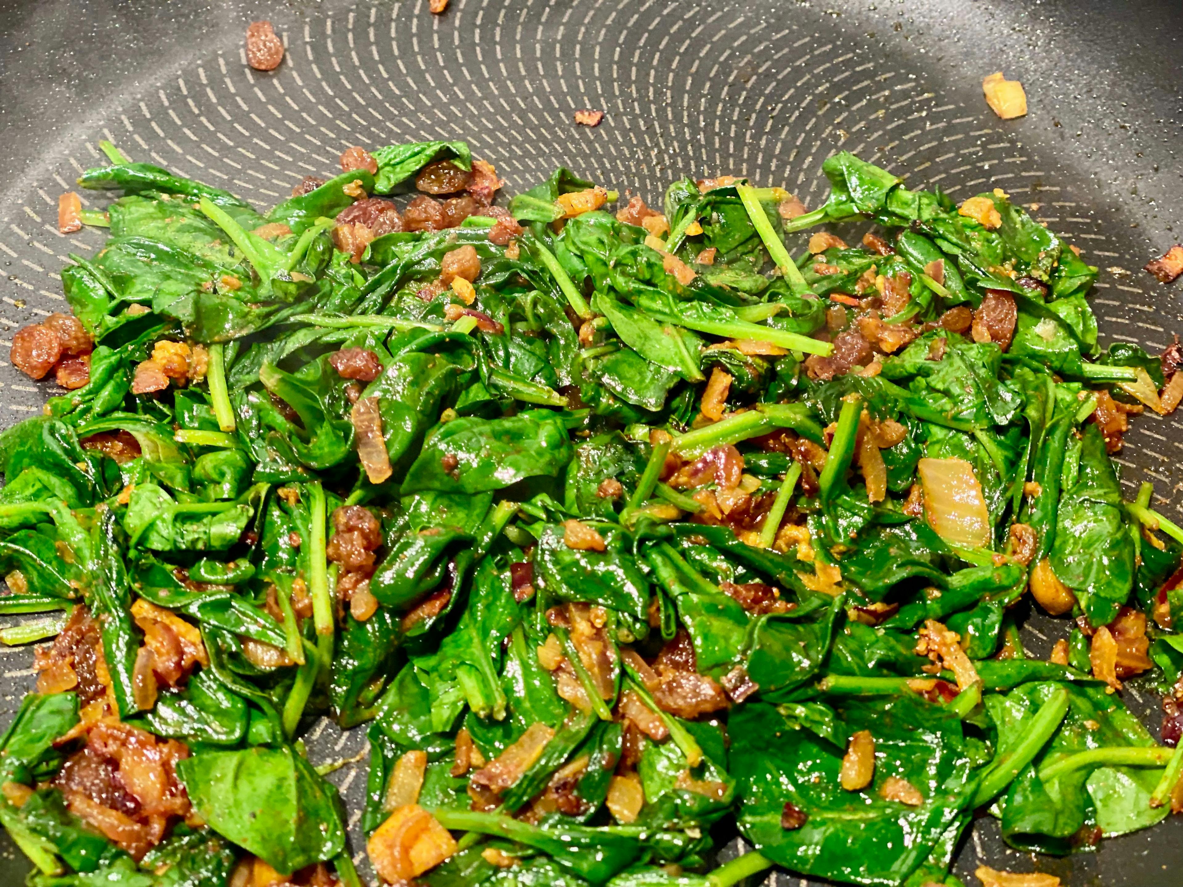 spinach and onions cooking in frypan
