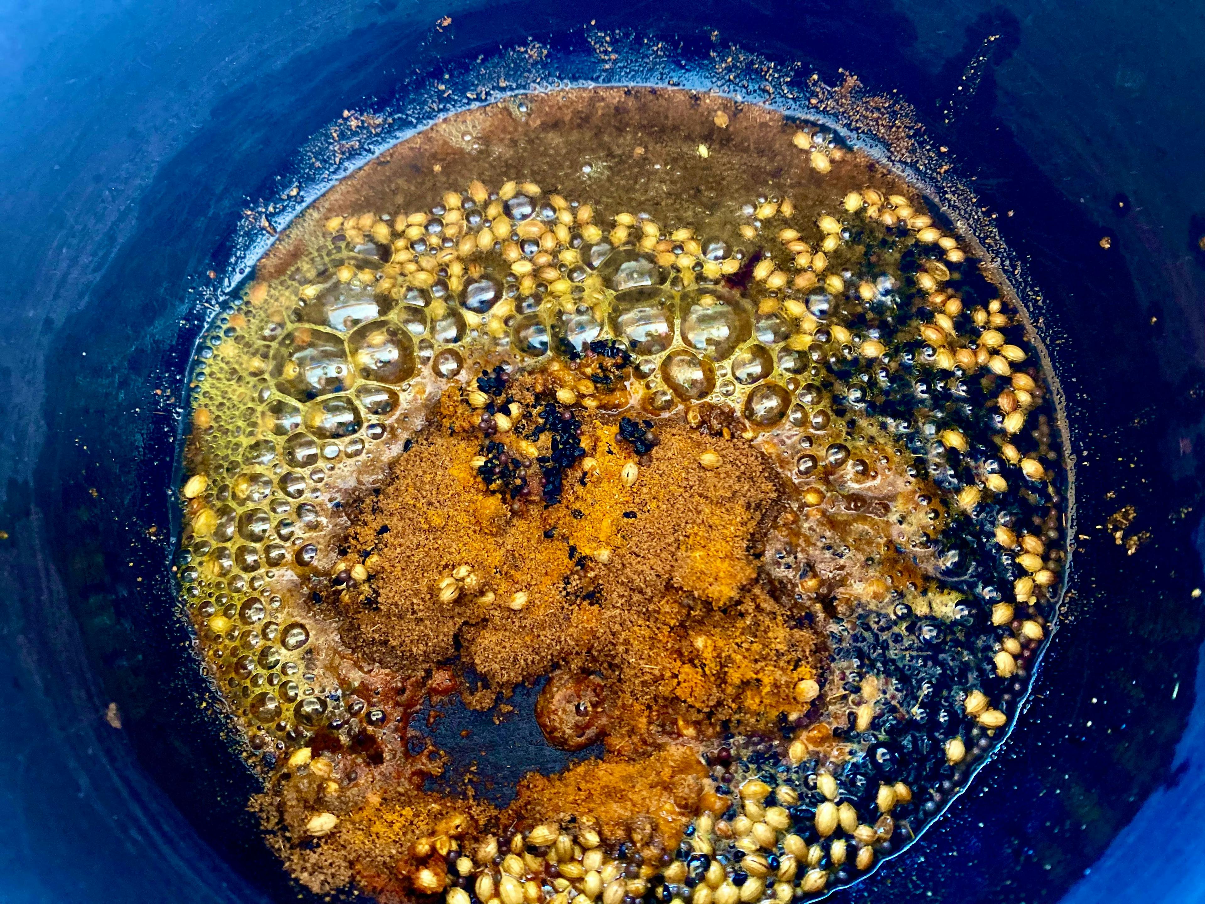 spices being fried in a saucepan