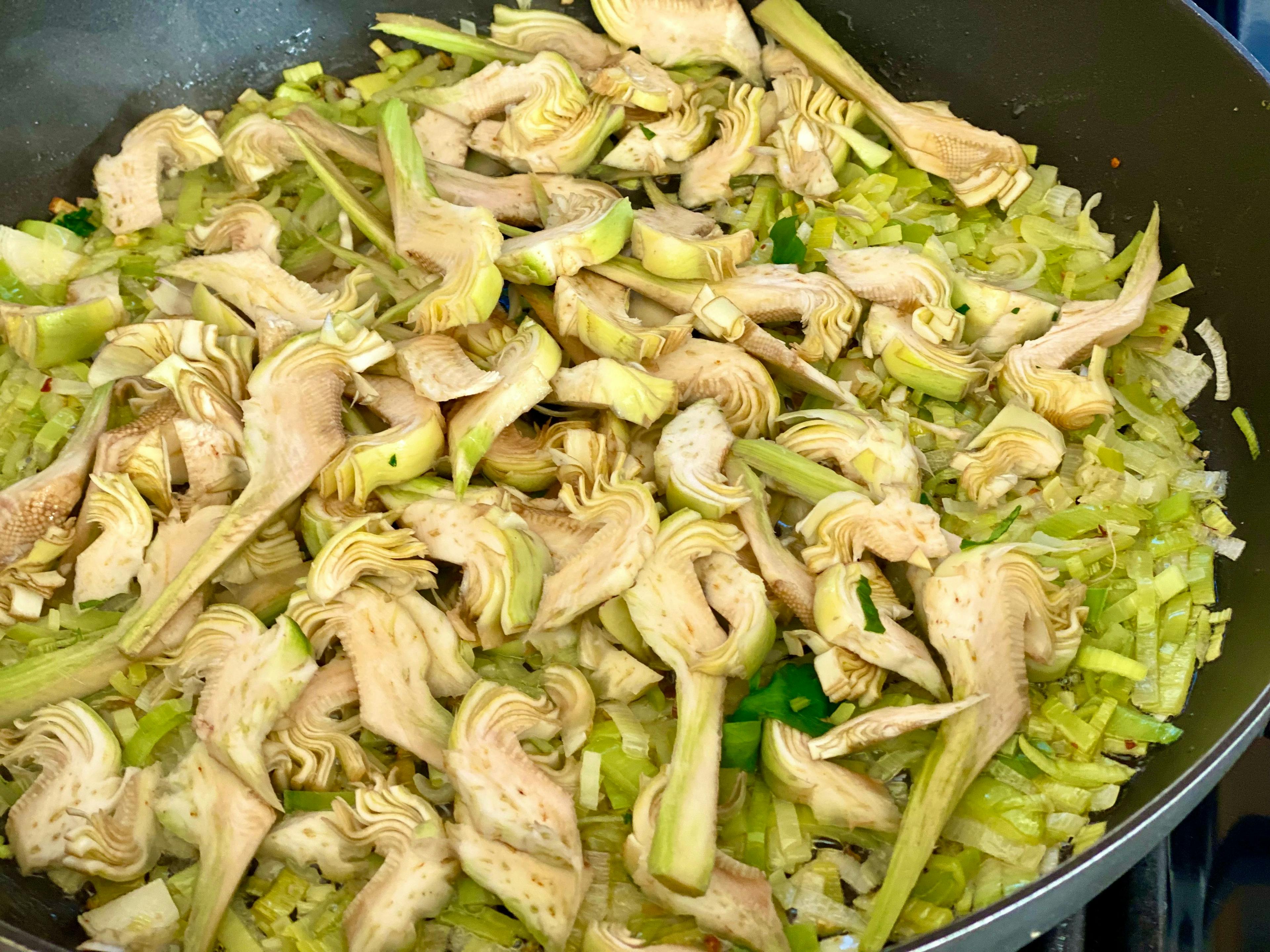 fry pan with leeks and artichoke slices cooking